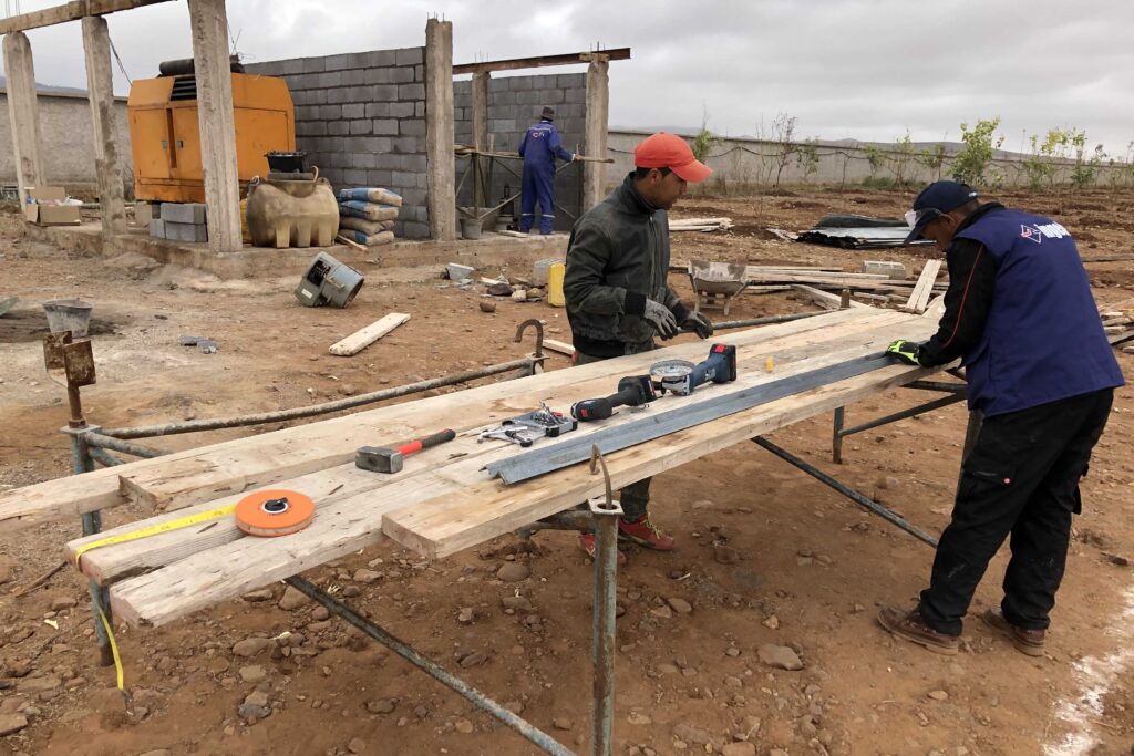 Local team working on inverter shack and PV mounting structures