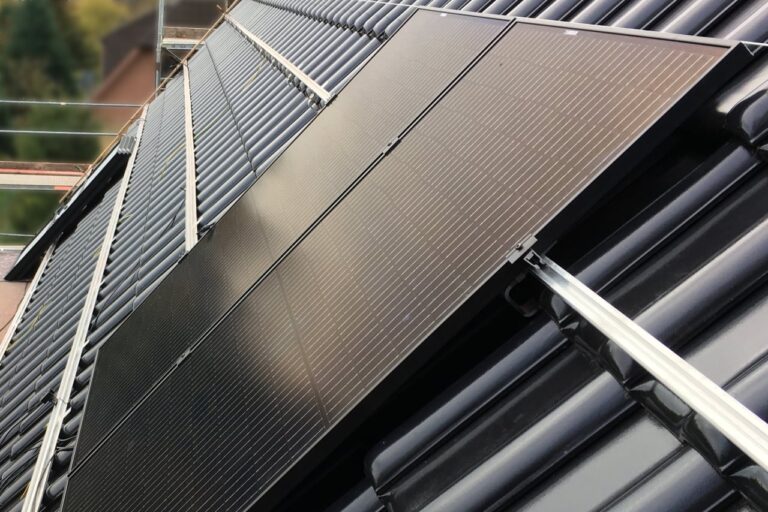 Fully black PV panels being installed on a pitched roof